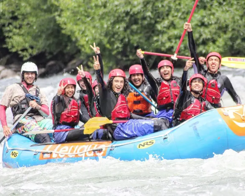 Grupo de PR Tours en una balsa de rafting levantando los remos